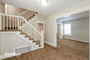 Kansas City house for rent - a living room with a staircase and a carpeted floor