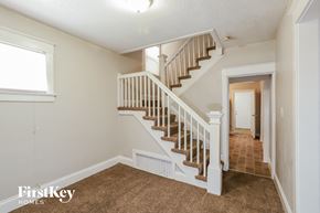 Kansas City house for rent - the landing of a staircase in a home with carpeted floors and a door to
