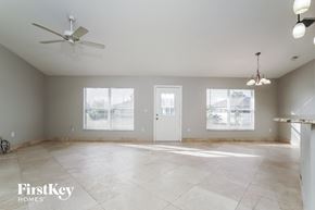 Cape Coral house for rent - an empty living room with a ceiling fan and two windows