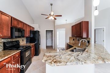 Cape Coral house for rent - a kitchen with black appliances and granite counter tops