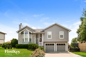 Raymore house for rent - A house with a garage and a driveway is shown in the image.