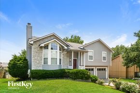 Raymore house for rent - A house with a well-maintained lawn and a clear blue sky above.
