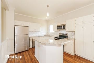 Raymore house for rent - A kitchen with white cabinets and a white island.