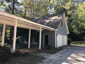 Conyers house for rent - A small house with a grey roof and white garage doors.