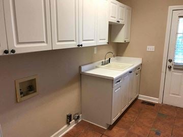 Conyers house for rent - A kitchen with white cabinets and a white sink.