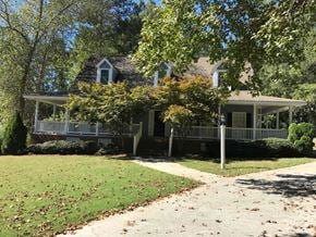 Conyers house for rent - A house with a porch and a tree in front of it.