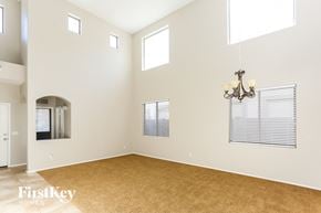Goodyear house for rent - an empty living room with a rug and a chandelier