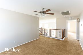 Goodyear house for rent - an empty living room with a ceiling fan and a staircase