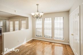 Memphis house for rent - an empty dining room with windows and a chandelier