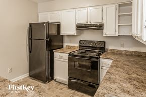 Memphis house for rent - a kitchen with stainless steel appliances and white cabinets