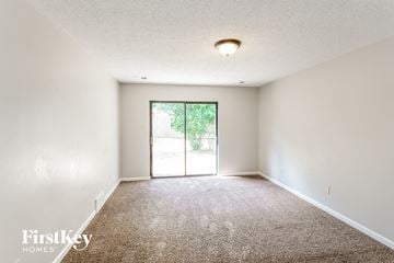 Memphis house for rent - a spacious living room with carpet and a door to the patio