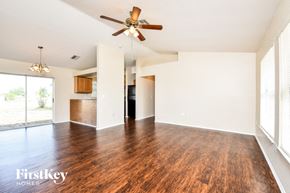 Cape Coral house for rent - A spacious room with wooden floors and a ceiling fan.