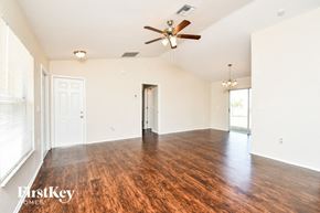 Cape Coral house for rent - A spacious room with wooden floors and a ceiling fan.