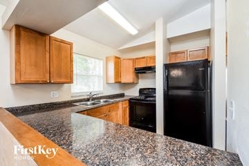 Cape Coral house for rent - A kitchen with granite countertops and wooden cabinets.