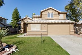 Goodyear house for rent - a beige house with a garage and a lawn