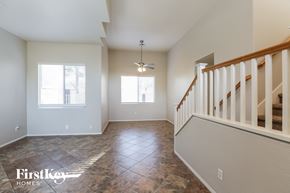 Goodyear house for rent - an empty living room with a staircase and a ceiling fan