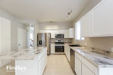 Goodyear house for rent - a large kitchen with marble counter tops and stainless steel appliances