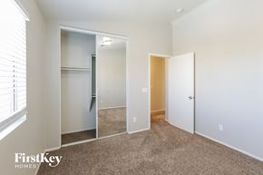 Goodyear house for rent - a bedroom with a closet and a window and a carpeted floor