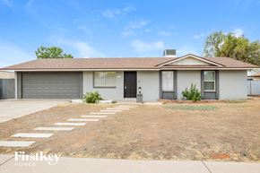Phoenix house for rent - a white house with a large yard and a garage door