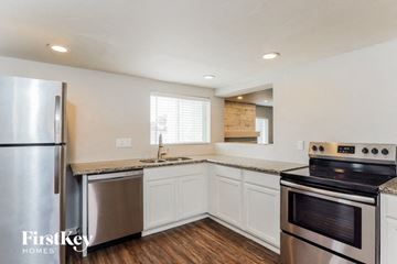 Phoenix house for rent - a kitchen with white cabinets and stainless steel appliances