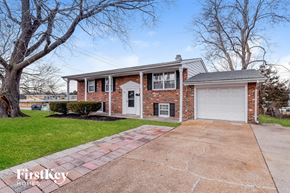 Florissant house for rent - a brick house with a white garage door on a driveway