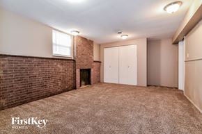 Florissant house for rent - a living room with a brick fireplace and a carpeted floor