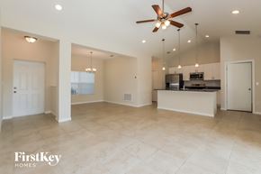 North Port house for rent - an empty kitchen and living room with a ceiling fan