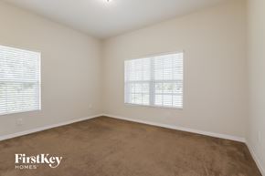North Port house for rent - a bedroom with a carpeted floor and two windows