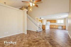 Surprise house for rent - A spacious living room with a staircase and a ceiling fan.