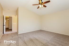 Surprise house for rent - A spacious room with a ceiling fan and carpeted floor.