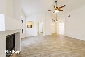Phoenix house for rent - A spacious room with a fireplace and a ceiling fan.