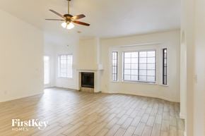 Phoenix house for rent - A spacious living room with a fireplace and a ceiling fan.