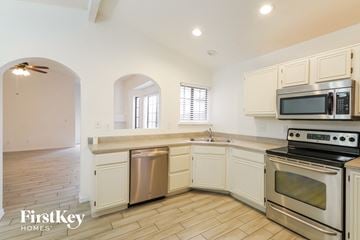 Phoenix house for rent - A kitchen with a stove top oven and a microwave above the sink.