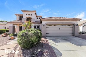 Surprise house for rent - a house with a garage door and a driveway