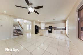 Surprise house for rent - an open kitchen and living room with a ceiling fan