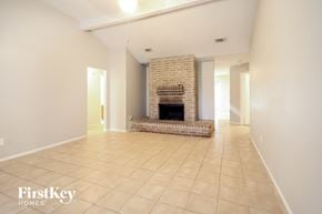 Houston house for rent - A spacious living room with a fireplace and tiled flooring.