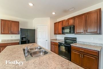 Cape Coral house for rent - A kitchen with wooden cabinets and a granite countertop.