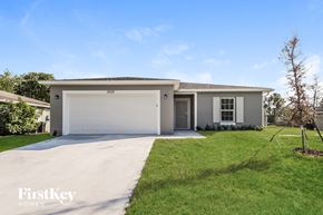 Palm Bay house for rent - a white house with a driveway and a garage door
