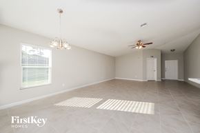 Palm Bay house for rent - a spacious living room with tile flooring and a ceiling fan
