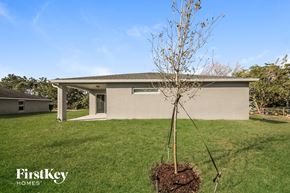Palm Bay house for rent - a tree in the grass in front of a house