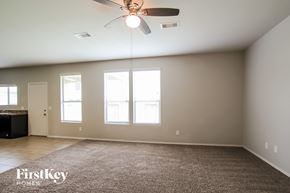 Houston house for rent - A spacious room with a ceiling fan and large windows.