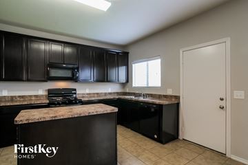 Houston house for rent - A kitchen with black cabinets and a countertop with a microwave on it.