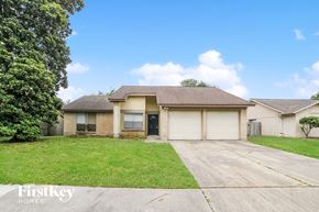 Houston house for rent - a yellow house with a lawn and a driveway