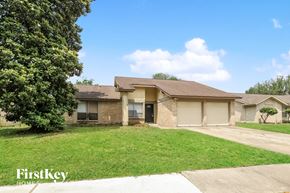 Houston house for rent - a tan brick house with a yard and a tree
