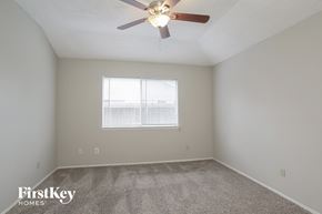Houston house for rent - a bedroom with a ceiling fan and a window