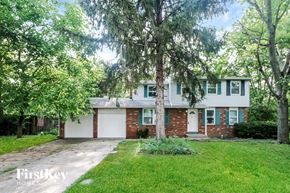 Indianapolis house for rent - a white and brick house with trees in front of it