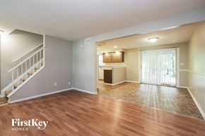 Indianapolis house for rent - an empty living room with a staircase and a kitchen