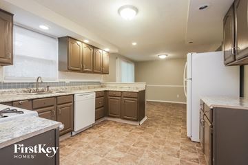 Indianapolis house for rent - a kitchen with white appliances and brown cabinets