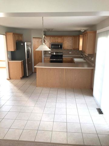 Crest Hill house for rent - an empty kitchen with wooden cabinets and a white tiled floor