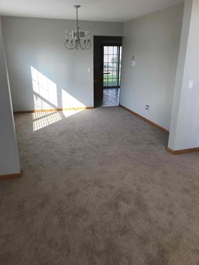 Crest Hill house for rent - an empty living room with carpet and a chandelier